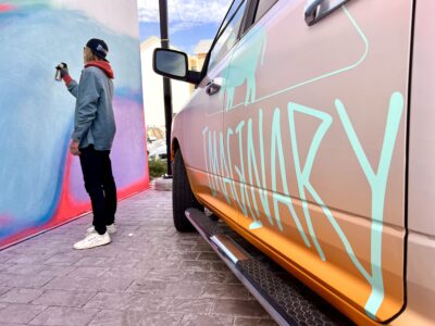 TJ Eisenhart works on a mural next to his truck labeled with his Imaginary Collective logo, March 23, 2022, St. George, Utah | Photo by Jessi Bang, St. George News