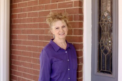 Leanne Worwood stands in front of Rockmore Retreats, a home she and her husband purchased and renovated, Hildale, Utah, May 2, 2022 | Photo by Jessi Bang, St. George News