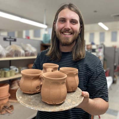 Ridge Merrill holds a few of his unfired mugs, location and date unspecified | Photo courtesy of Ridge Merrill, St. George News