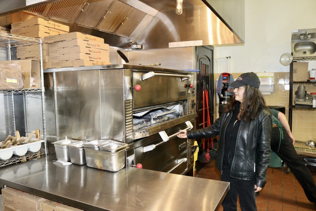 Marie Perez shows her pizza oven inside Bella Marie's Pizzeria in St. George, Utah, December 14, 2022 | Photo Credit: Jessi Bang, St. George News