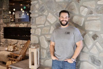 Joe Solomon smiles for the camera inside Wood Ash Rye in St. George, Utah, Dec. 21, 2022 | Photo by Jessi Bang, St. George News