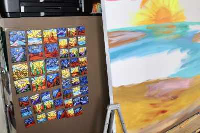Hand-painted magnets sit next to the initial stages of a new painting, St. George, Utah, Feb. 27, 2023 | Photo by Jessi Bang, St. George News
