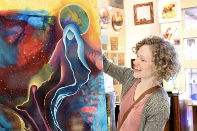 Darcy Lee Saxton holds one of her paintings inside Gallery 873 in Ivins, Utah, Oct. 25, 2023 | Photo by Jessi Bang, St. George News