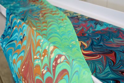 Completed silk marbling designs sit on a table inside Lynda Holman's art studio in St. George, Utah, Nov. 30, 2023 | Photo by Jessi Bang, St. George News