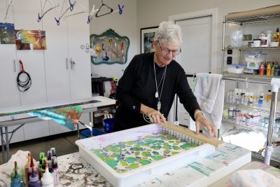 Artist Lynda Holman stands makes a silk marbling design at her home art studio in St. George, Utah, Nov. 30, 2023 | Photo by Jessi Bang, St. George News